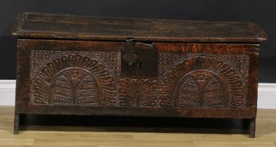 A 17th century oak six plank chest, of boarded construction, hinged top, the front carved with two