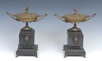 A pair of Art Nouveau bronze and belge noir marble covered urns, each with bird of prey finial,