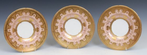 A set of three Coalport shaped circular dishes, each profusely decorated with tooled and burnished