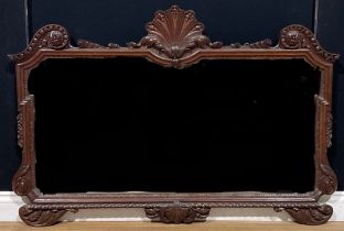 A mahogany chimney glass, shaped mirror plate, the frame crested by a shell flanked by egg-and-