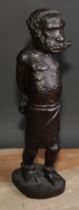 Slavery - a West African tribal hardwood carving, of a slave in chains, 39cm high