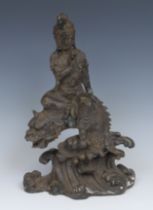 Chinese School, a patinated bronze, Guanyin seated on a dragon, 30cm high