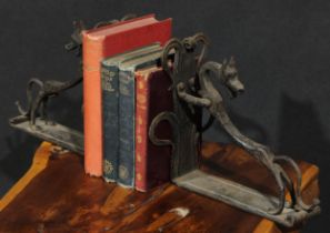 A pair of Arts and Crafts wrought iron book ends, each worked with a stylised dog, the uprights with