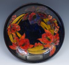 A Moorcroft Iris pattern charger, tube lined on a mottled blue ground, 31.5cm diameter, impressed