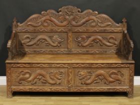 A Chinese hardwood hall bench, profusely carved with dragons, trellis and other traditional