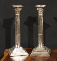 A pair of Elizabeth II silver stop-fluted Corinthian column table candlesticks, of George III