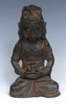 Chinese School, a brown patinated bronze, Guanyin, seated in meditation, holding a tea or wine