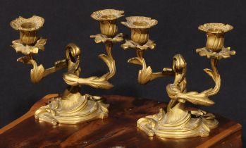 A pair of 19th century Rococo Revival gilt bronze two-light candelabra, cast throughout with