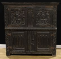 A 16th century French oak Romayne panel food cupboard, oversailing top above a pair of doors