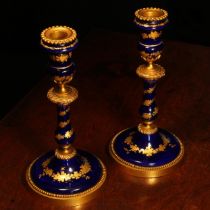 A pair of 19th century French gilt metal mounted enamel table candlesticks, decorated with bands