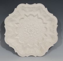 A Royal Worcester parian shaped circular plate, moulded in the Orientalist taste with lotus, 30.