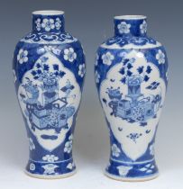 A near pair of 19th century Chinese blue and white baluster form vases, decorated with two panels of