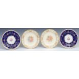 A pair of Royal Crown Derby shaped circular plates, painted with central sprays of dog roses on