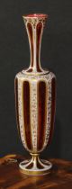 A Bohemian overlaid ruby glass panelled ovoid vase, decorated in gilt with dense scrolling leaves,