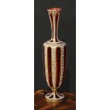 A Bohemian overlaid ruby glass panelled ovoid vase, decorated in gilt with dense scrolling leaves,