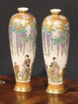 A pair of Japanese Satsuma slender ovoid vases, painted with geisha beneath hanging wisteria, 18cm
