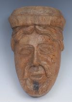 An English figural oak carving or corbel, carved with an asymmetrical mask of a bearded man, 15th