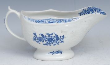 A Lowestoft sauceboat, moulded in relief with flowerheads, decorated in underglaze blue with