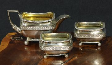 A George III silver three piece table suite, comprising a condiment jug and a pair of salts, each