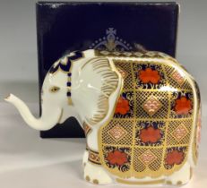 A Royal Crown Derby paperweight, Elephant, decorated in the 1128 Imari palette, trunk raised, gold