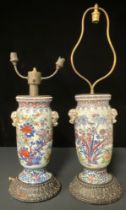 A pair of early 19th century Chinese vases, converted to lamps, on carved wooden bases (vase bases