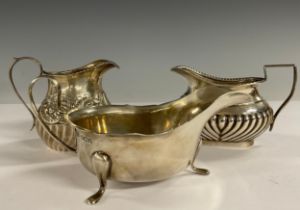 A silver sauceboat; two silver cream jugs