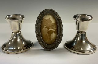 A pair of Elizabeth II silver boudoir candlesticks, Birmingham 1957; a George V silver oval