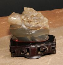 A Chinese hardstone seal, carved with a dragon, 6.5cm wide, hardwood stand