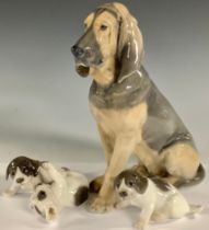 A Royal Copenhagen model of a sitting Bloodhound, model number 1322, 22cm, printed mark; two smaller