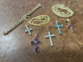 A 9ct gold, aquamarine and diamond crucifix pendant, the oval cut claw set stones divided by small