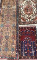 A Middle Eastern rectangular woollen rug or carpet, with geometric motifs, in tones of red, blue,