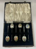 A set of six silver plated and enamel coffee spoons, each decorated in polychrome with English