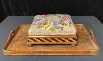 A Victorian inlaid footstool, woolwork floral upholstered; a Victorian oak tray (2)