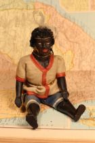 An early 20th century black composition jointed doll, painted features, black flock type hair,