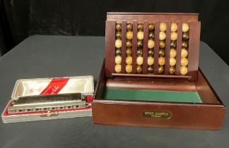 A Larry Adler harmonica, boxed; a Remy Martin promotional "connect four" game (2)