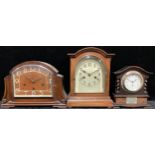 An Edwardian oak mantel clock, arched case, glazed bevelled door, the dial with Arabic numerals,