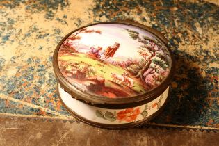 A 19th century enamel circular table snuff box, hinged cover painted with young shepherds in a