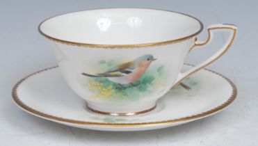 A Royal Worcester teacup and saucer, painted by D. Jones, signed, with a chaffinch and a yellow