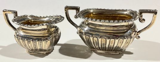 A matched late Edwardian/George V silver milk jug and sugar bowl, boat shaped, stop fluted, the