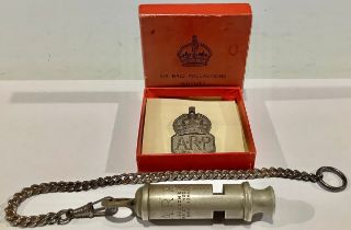 A silver ARP badge, in original box; an ARP whistle (2)