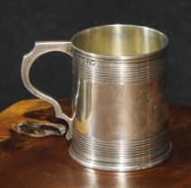 A Victorian silver christening mug, moulded rim above two deep reeded bands, shaped scroll handle,