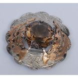 A Scottish silver and gold coloured metal shaped circular plaid brooch, applied with thistles and