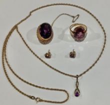 A composed suite of 9ct gold and amethyst jewellery, comprising faceted oval brooch, pin clasp