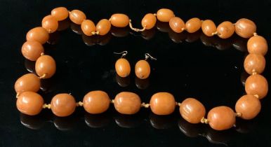 A single strand of twenty eight butterscotch amber polished oval graduated beads, the largest 3cm,