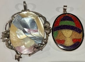 A silver mounted mother of pearl pendant, stylised lady wearing hat, marked 925; another, similar,