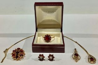 A composed suite of 9ct gold and garnet jewellery, comprising, a 9ct gold brooch set with a flower