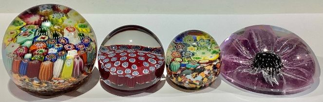 A millefiori glass paperweight; two others smaller; another with flower inclusion (4)