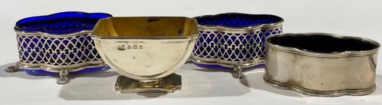 A matched pair of silver quatrefoil mustards, reticulated sides, blue glass liners, four scallop