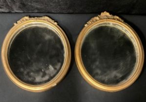 A pair of oval gilt mirrors, the cornice a palmette flanked by acanthus leaves (2)