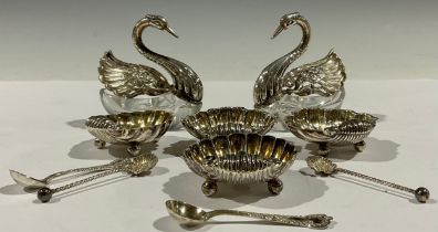 A pair of Victorian silver scallop shell shaped table salts and spoons, three ball feet, Chester